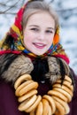 A young girl in a Russian scarf and with a bunch of sheep in the winter landscape Royalty Free Stock Photo