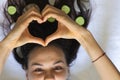 Young girl`s hair twisted heart folded with spa stones and cucumbers