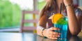 Young girl`s hand holding a glass with a blue lemonade cocktail with fruits Royalty Free Stock Photo