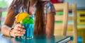 Young girl`s hand holding a glass with a blue lemonade cocktail with fruits Royalty Free Stock Photo