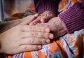 Young girl's hand touches and holds an old woman hand