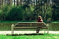 Young girl sad and sit on a wooden bench in the Park, she was disappointed by the sweet love. dreams of the future.