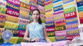 Girl salesman of the department store selling bright terry bath towels with a dedicatory inscription