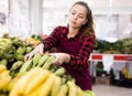 Young girl a salesperson puts bananas on the counter