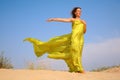 Young girl on sand in yellow fabric shawl