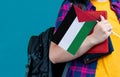 Young girl with school stuff holds in hand Palestine flag close up