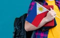 Young girl with school stuff holds in hand Philippines flag close up