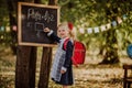 Young girl in school uniform writing on a board outdoor. Back to school