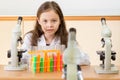 Young girl scientist with microscope and test tubes in science l Royalty Free Stock Photo