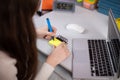 A young girl is scrawling words in English on small pieces of paper. Royalty Free Stock Photo