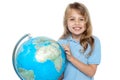 Young girl selecting holiday destination over globe Royalty Free Stock Photo