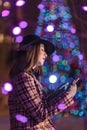 Young girl sending sms christmass wishes during winter alone in Royalty Free Stock Photo