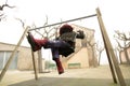 Young girl sheltered in abandoned swing set, unrecognisable