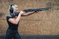 A young girl shoots a shotgun with high recoil at a shooting range Royalty Free Stock Photo