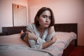 Young girl with short hair in a sweater, denim skirt lying alone on the bed in the bedroom