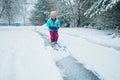 A young girl shoveling snow