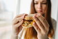 A young girl shows that she does not like a burger. Conceptual image of refusal from unhealthy eating. Royalty Free Stock Photo