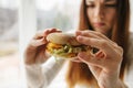 A young girl shows that she does not like a burger. Conceptual image of refusal from unhealthy eating. Royalty Free Stock Photo
