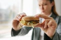 A young girl shows that she does not like a burger. Conceptual image of refusal from unhealthy eating. Royalty Free Stock Photo