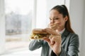 A young girl shows that she does not like a burger. Conceptual image of refusal from unhealthy eating. Royalty Free Stock Photo