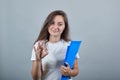 Young girl with blue folder shows sign okay Royalty Free Stock Photo