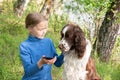 A young girl shows something to her dog in a mobile phone. A child plays with a dog and telephone Royalty Free Stock Photo