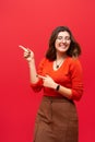 Young girl shows thumbs up on the background of a red wall. Career growth and motivation. Place for inscription Royalty Free Stock Photo