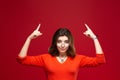 Young girl shows thumbs up on the background of a red wall. Career growth and motivation. Place for inscription Royalty Free Stock Photo