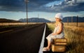 Young girl on side of road with suitcases Royalty Free Stock Photo