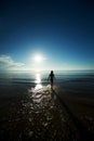 Young girl silhouette walking in the sea