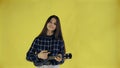 Young girl singing and playing ukulele on yellow Background in Studio Royalty Free Stock Photo