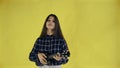 Young girl singing and playing ukulele on yellow Background in Studio Royalty Free Stock Photo