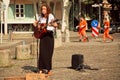 Young girl singing songs with guitar on cobbles street Royalty Free Stock Photo