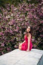 Young girl sist in front of sakura tree. Spring outside. Blossom tree Royalty Free Stock Photo