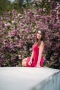 Young girl sist in front of sakura tree. Spring outside. Blossom tree Royalty Free Stock Photo