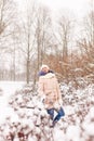 A Young Girl Sits On A Bench In A Snowy Park