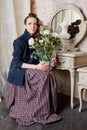 Young girl sits with dreamy look and holding flowerpot Royalty Free Stock Photo