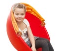 A young girl sits in a red chair Royalty Free Stock Photo