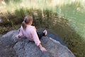 A young girl sits on a stone on the shore and wets her feet in the Zavitan stream in the Yehudia National Natural Park in