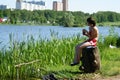 Young girl sits at water and fishes Royalty Free Stock Photo