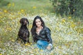 Young girl sittin in flower field together with German Pointer