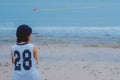 Young girl sitting on the beach in the early morning