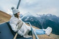 Young girl sitting in cable chair and looking at mountains