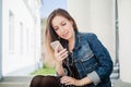 Young girl sitting on the college campus yard listening music Royalty Free Stock Photo