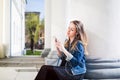 Young girl sitting on the college campus yard listening music Royalty Free Stock Photo