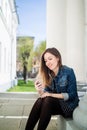 Young girl sitting on the college campus yard listening to music Royalty Free Stock Photo