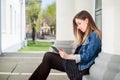 Young girl sitting on the college campus yard studying Royalty Free Stock Photo