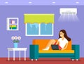 A young girl sitting on the couch and working on a laptop online. The concept of freelancing and shopping online. Room interior Royalty Free Stock Photo