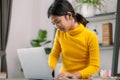 A young girl is sitting at a desk with a laptop in front of her Royalty Free Stock Photo