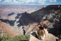 young girl sitting on the edge of the cliff of the Grand Canyon taking photos